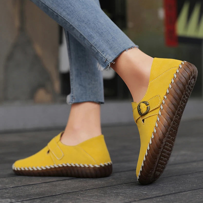 Yellow loafers worn with blue jeans on a blurred background